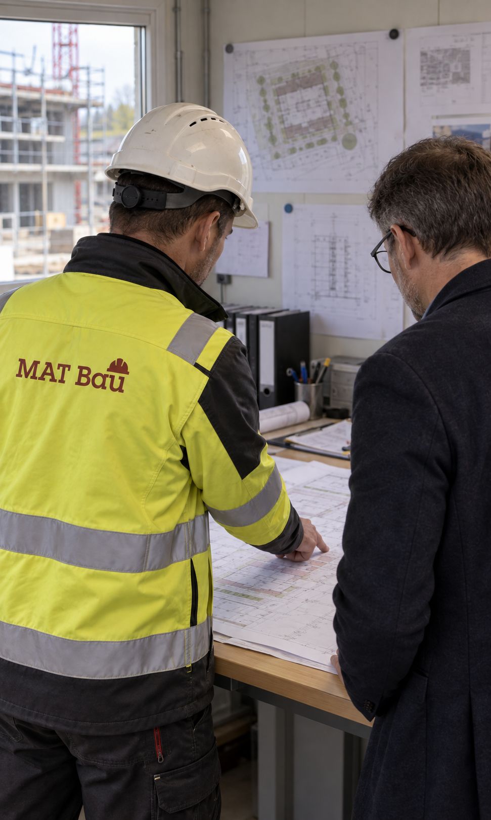 Fachkräfte in Warnkleidung und Helm bereiten Schalungselemente vor, dahinter hängt ein Betonkübel am Kran.